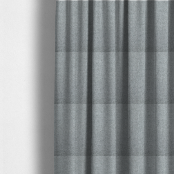 The fabric used to create these made-to-measure curtains is a textured, light grey or silver grey woven upholstery fabric.