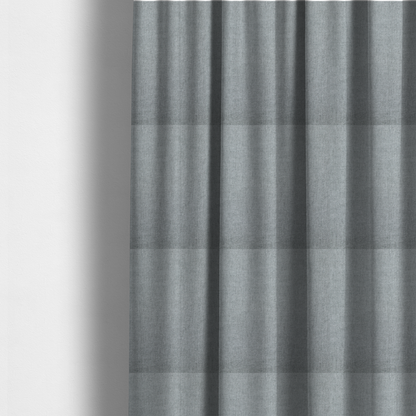 The fabric used to create these made-to-measure curtains is a textured, light grey or silver grey woven upholstery fabric.