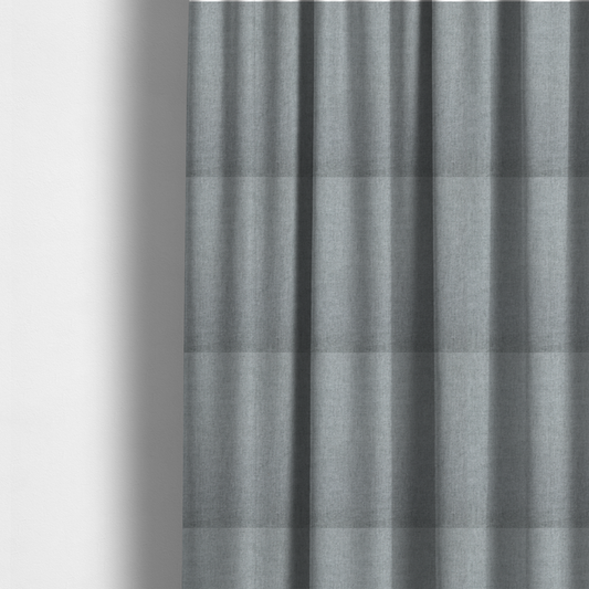 The fabric used to create these made-to-measure curtains is a textured, light grey or silver grey woven upholstery fabric.