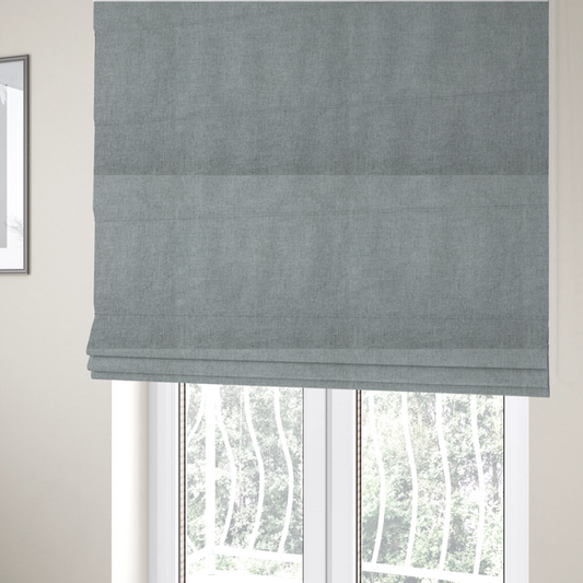 The fabric used to create these Roman blinds is a  textured, light grey or silver grey woven upholstery fabric.