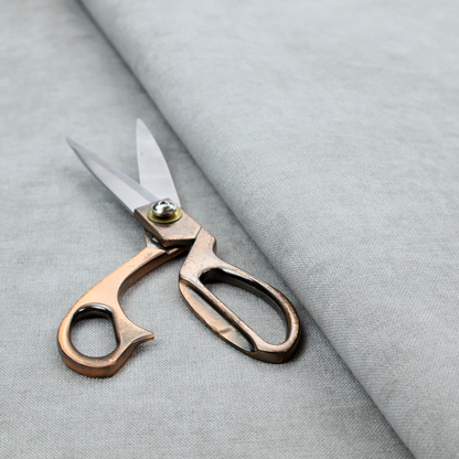 A textured, very light grey or off-white woven upholstery fabric.