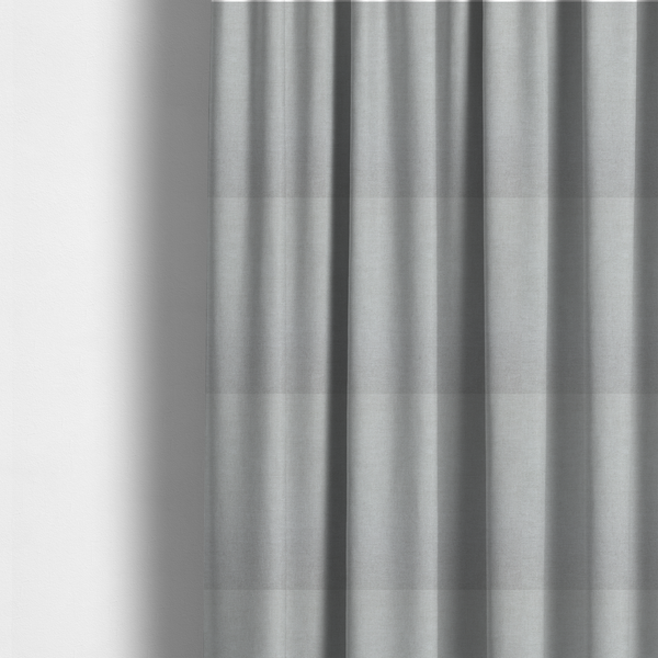 The fabric used to create these made-to-measure curtains is a textured, very light grey or off-white woven upholstery fabric.