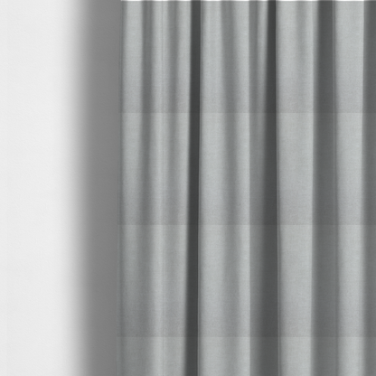 The fabric used to create these made-to-measure curtains is a textured, very light grey or off-white woven upholstery fabric.