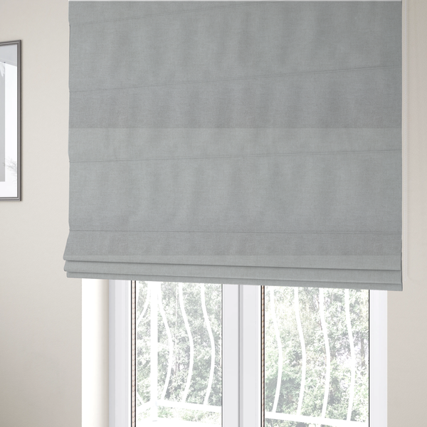 The fabric used to create these Roman blinds is a textured, very light grey or off-white woven upholstery fabric.