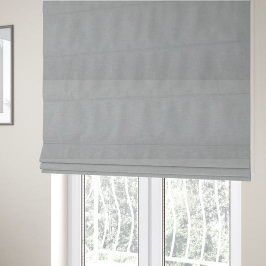The fabric used to create these Roman blinds is a textured, very light grey or off-white woven upholstery fabric.