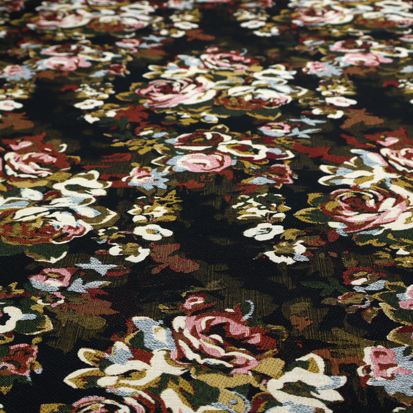 A repeating vintage floral pattern on a dark black and olive green woven fabric background. The pattern features clusters of blooming roses in shades of dusty pink, burgundy, cream, and muted light blue, accompanied by small accent flowers and olive green leaves.   