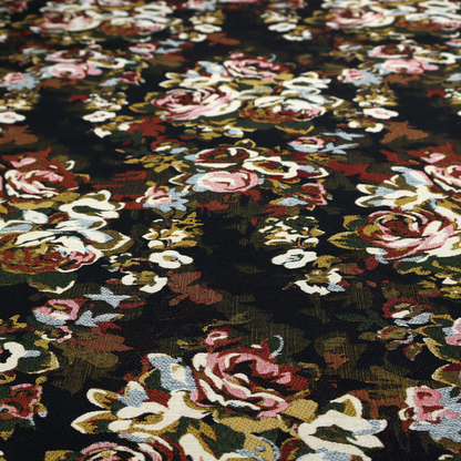 A repeating vintage floral pattern on a dark black and olive green woven fabric background. The pattern features clusters of blooming roses in shades of dusty pink, burgundy, cream, and muted light blue, accompanied by small accent flowers and olive green leaves.   