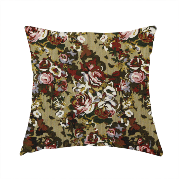 The fabric used to create this handmade cushion is a repeating vintage floral pattern on a warm gold and beige textured woven fabric background. The design features dense clusters of blooming roses in shades of dusty pink, deep red, cream, and muted lavender, surrounded by olive green and dark foliage.   