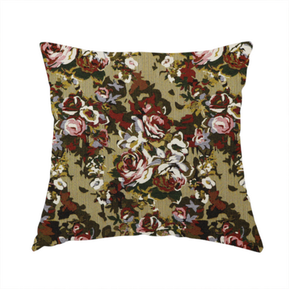 The fabric used to create this handmade cushion is a repeating vintage floral pattern on a warm gold and beige textured woven fabric background. The design features dense clusters of blooming roses in shades of dusty pink, deep red, cream, and muted lavender, surrounded by olive green and dark foliage.   