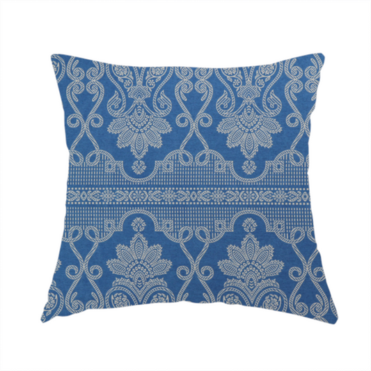 The fabric used to create this handmade cushion is an ornate, traditional damask upholstery fabric on a rich blue background featuring intricate cream-coloured symmetrical floral and paisley motifs divided horizontally by a decorative lattice and scroll border.   