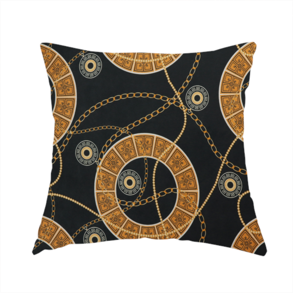 The fabric used to create this handmade cushion is a glamorous luxury-style upholstery fabric on a black background featuring a repeating pattern of large gold-and-white patterned circular rings interconnected by dangling gold chains and small black-and-white geometric medallions.   