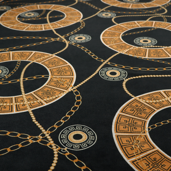A glamorous luxury-style upholstery fabric on a black background featuring a repeating pattern of large gold-and-white patterned circular rings interconnected by dangling gold chains and small black-and-white geometric medallions.   