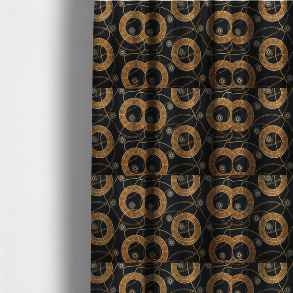 The fabric used to create these made-to-measure curtains is a glamorous luxury-style upholstery fabric on a black background featuring a repeating pattern of large gold-and-white patterned circular rings interconnected by dangling gold chains and small black-and-white geometric medallions.   