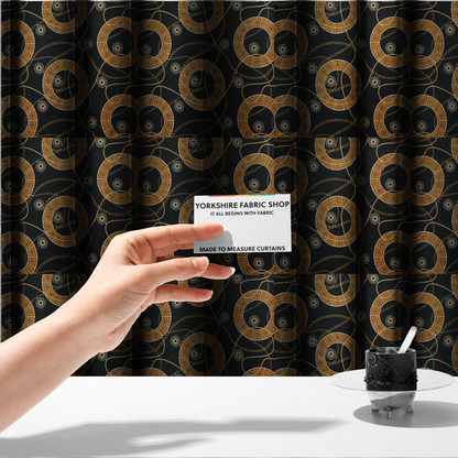 The fabric used to create these made-to-measure curtains is a glamorous luxury-style upholstery fabric on a black background featuring a repeating pattern of large gold-and-white patterned circular rings interconnected by dangling gold chains and small black-and-white geometric medallions.   