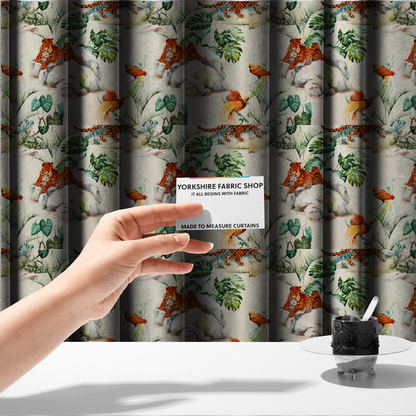 The fabric used to create these made-to-measure curtains s a tropical fabric pattern featuring leopards lounging on rocks amidst lush green foliage, palm fronds, and vibrant orange birds against a light background.