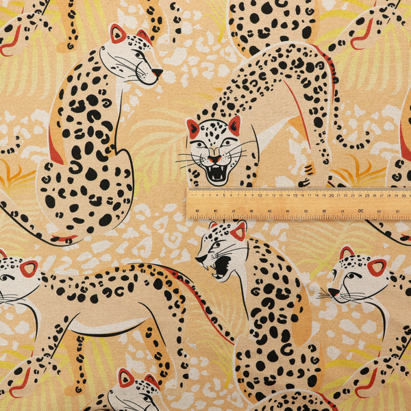 A playful patterned fabric featuring illustrated leopards in various poses with black spots and red-tipped ears, set against a warm yellow and beige jungle foliage background.   