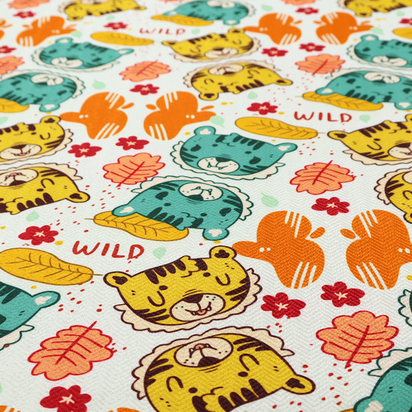 A playful cartoon fabric print on a light background featuring alternating yellow and turquoise tiger cub faces, orange cactus silhouettes, yellow leaves, red flower blossoms, and the word "WILD" written in red text.   
