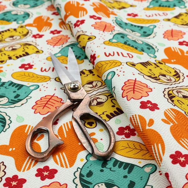 A playful cartoon fabric print on a light background featuring alternating yellow and turquoise tiger cub faces, orange cactus silhouettes, yellow leaves, red flower blossoms, and the word "WILD" written in red text.   