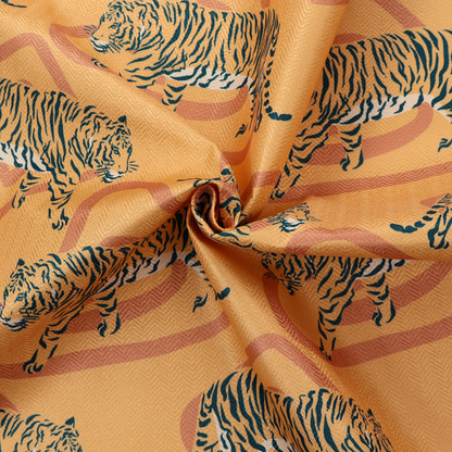 A striking upholstery fabric on a warm mustard-yellow background featuring a repeating pattern of prowling tigers in black stripes over abstract terracotta-coloured organic shapes.   