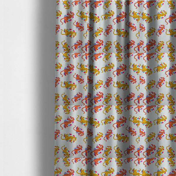 The fabric used to create these made-to-measure curtains is a playful patterned fabric featuring whimsical leaping tigers in shades of orange and yellow, accented with colourful floral elements on a light grey background.   