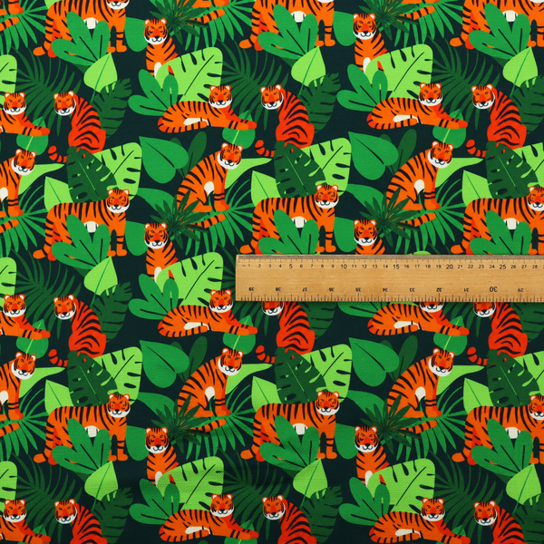A vibrant jungle pattern fabric featuring orange and black tigers nestled among lush green tropical leaves and foliage against a dark background.   