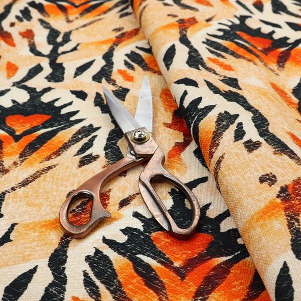 An abstract ikat fabric pattern featuring symmetrical, feather-like motifs in shades of burnt orange, cream, and dark charcoal black against a textured light background.   
