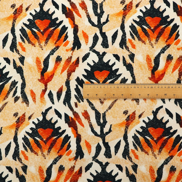 An abstract ikat fabric pattern featuring symmetrical, feather-like motifs in shades of burnt orange, cream, and dark charcoal black against a textured light background.   