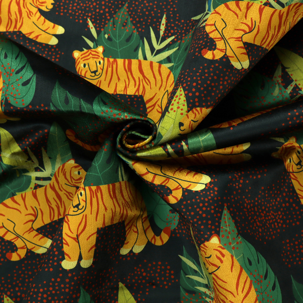 A vibrant fabric pattern featuring illustrated orange tigers in various poses surrounded by dark green tropical leaves and foliage against a dark background with red dotted accents.   