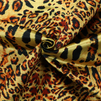 A bold, symmetrical leopard print fabric featuring a repeating kaleidoscope pattern of black and golden-brown rosettes on a warm yellow-gold background.
