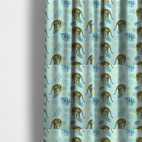 The fabric used to create these made-to-measure curtains is a tropical jungle upholstery fabric on a light mint-blue background featuring a repeating pattern of yellow and black tigers surrounded by teal monstera leaves, palm fronds, and yellow dot clusters.   