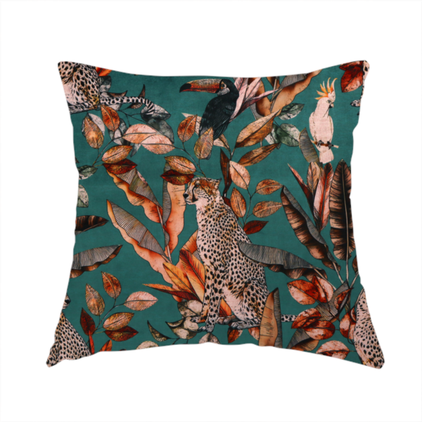 The fabric used to create this handmade cushion is a moody teal fabric pattern featuring seated leopards, a toucan, and a white cockatoo amidst autumn-toned tropical leaves and foliage.