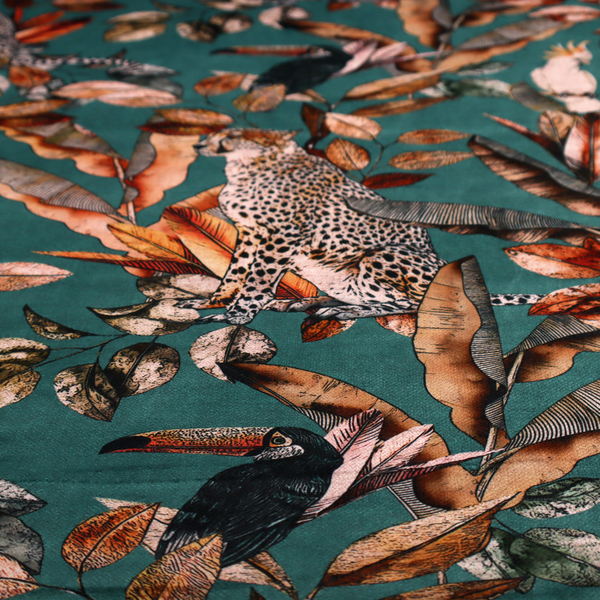 A moody teal fabric pattern featuring seated leopards, a toucan, and a white cockatoo amidst autumn-toned tropical leaves and foliage.