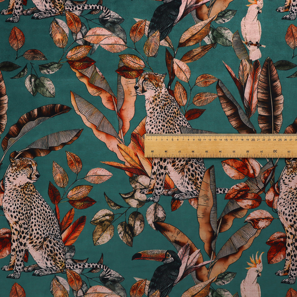 A moody teal fabric pattern featuring seated leopards, a toucan, and a white cockatoo amidst autumn-toned tropical leaves and foliage.