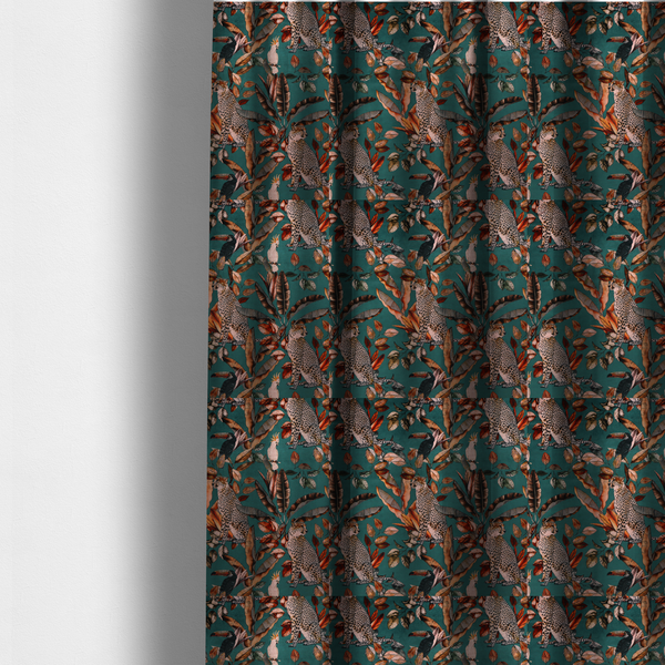 The fabric used to create these made-to-measure curtains is a moody teal fabric pattern featuring seated leopards, a toucan, and a white cockatoo amidst autumn-toned tropical leaves and foliage.