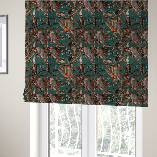 The fabric used to create these Roman blinds is a moody teal fabric pattern featuring seated leopards, a toucan, and a white cockatoo amidst autumn-toned tropical leaves and foliage.