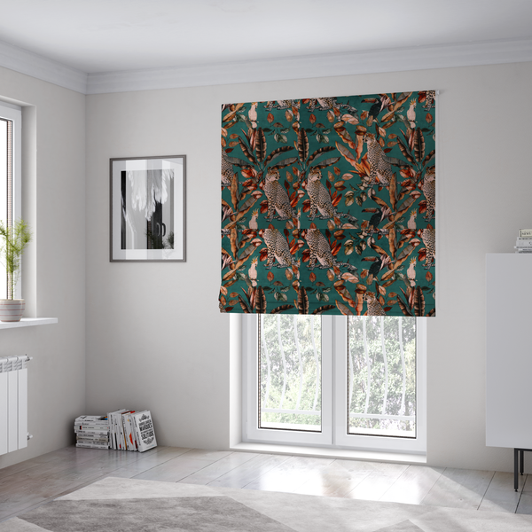 The fabric used to create these Roman blinds is a moody teal fabric pattern featuring seated leopards, a toucan, and a white cockatoo amidst autumn-toned tropical leaves and foliage.