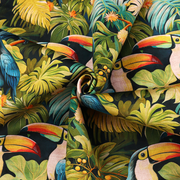 Tropical fabric featuring a repeating pattern of blue toucans perched among lush monstera leaves, palm fronds, and yellow flowers.   