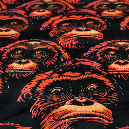 Fabric pattern featuring a repeating graphic illustration of orangutan faces in orange, peach, and reddish-pink tones against a dark black background.   