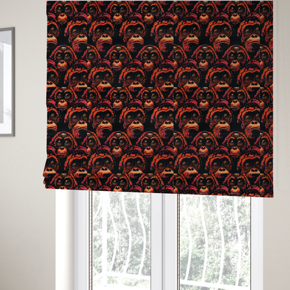 The fabric used to create these Roman blinds is a fabric pattern featuring a repeating graphic illustration of orangutan faces in orange, peach, and reddish-pink tones against a dark black background.   