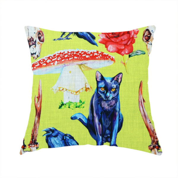the fabric used to create this handmade cushion is a chartreuse green fabric featuring a repeating pattern of black cats, blue ravens, red roses, horned animal skulls, and red fly agaric mushrooms.   