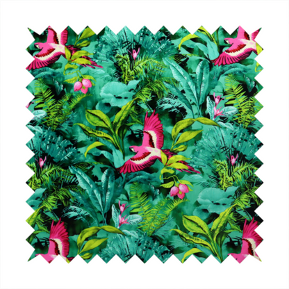 Tropical fabric featuring vibrant magenta parrots in flight surrounded by lush green palm fronds, banana leaves, and pink tropical flowers.   