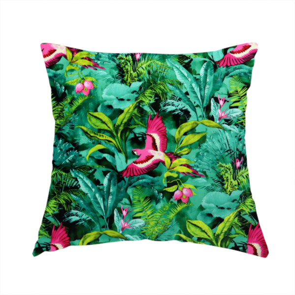 The fabric used to create this handmade cushion is a tropical fabric featuring vibrant magenta parrots in flight surrounded by lush green palm fronds, banana leaves, and pink tropical flowers.   