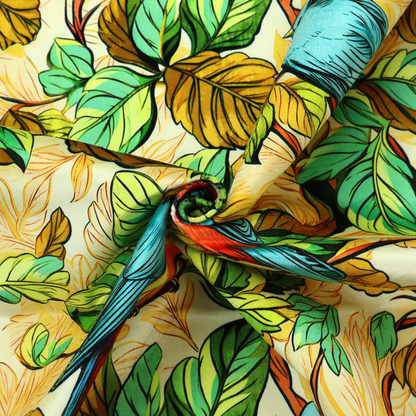Vibrant fabric featuring a repeating pattern of blue and orange songbirds perched among green, mustard yellow, and golden foliage on branches.