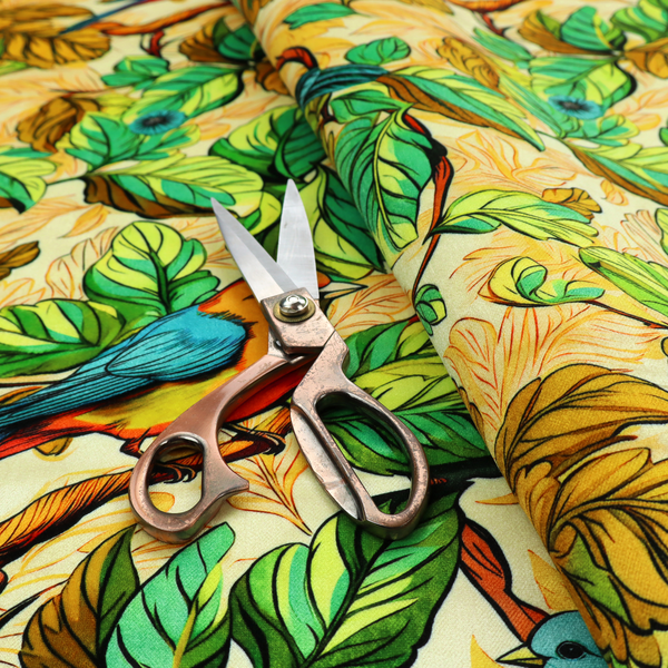 Vibrant fabric featuring a repeating pattern of blue and orange songbirds perched among green, mustard yellow, and golden foliage on branches.
