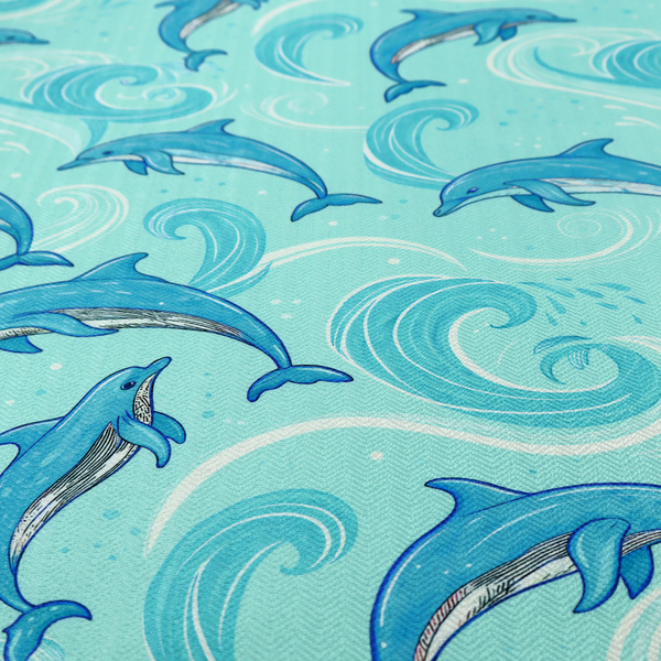 Aqua blue fabric with a repeating pattern of playful blue dolphins leaping through swirling white ocean waves and water splashes.   