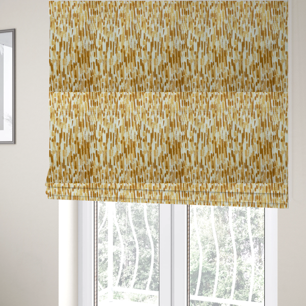 The fabric used to create these Roman blinds is a textured abstract pattern featuring vertical brushstrokes or chalk-like marks in shades of warm mustard yellow and golden brown against a light off-white or cream background.   