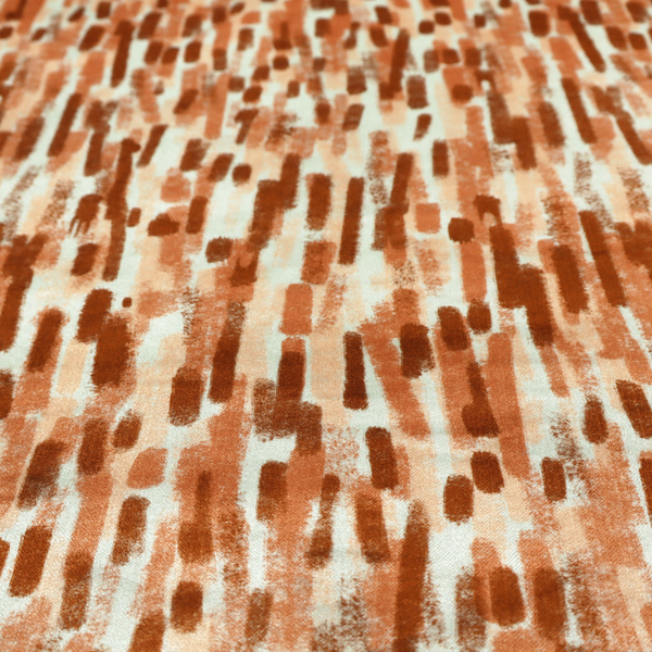 A textured abstract pattern featuring vertical brushstrokes or chalk-like marks in shades of warm terracotta and burnt orange against a light off-white or cream background.