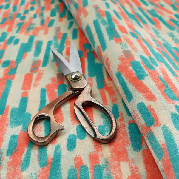 Fabric featuring an abstract, vertical brushstroke pattern in teal and coral red on an off-white background.   