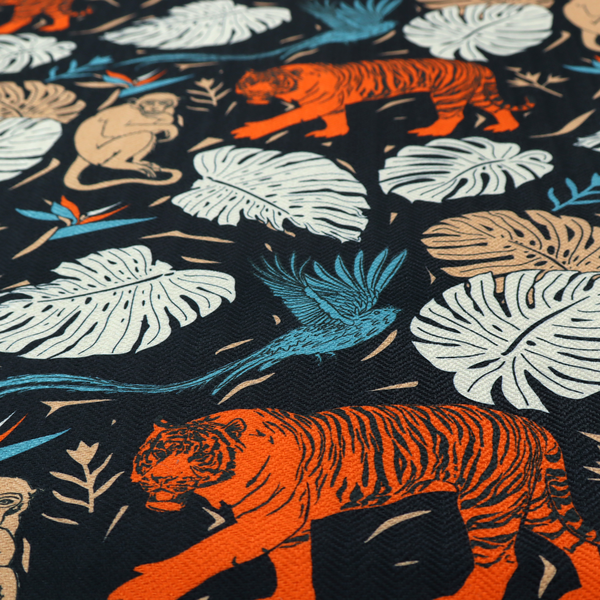 Fabric print featuring orange striped tigers, sitting beige monkeys, flying blue tropical birds, Monstera leaves, and bird of paradise flowers set against a dark navy background.   