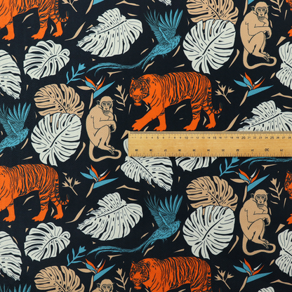 Fabric print featuring orange striped tigers, sitting beige monkeys, flying blue tropical birds, Monstera leaves, and bird of paradise flowers set against a dark navy background.   